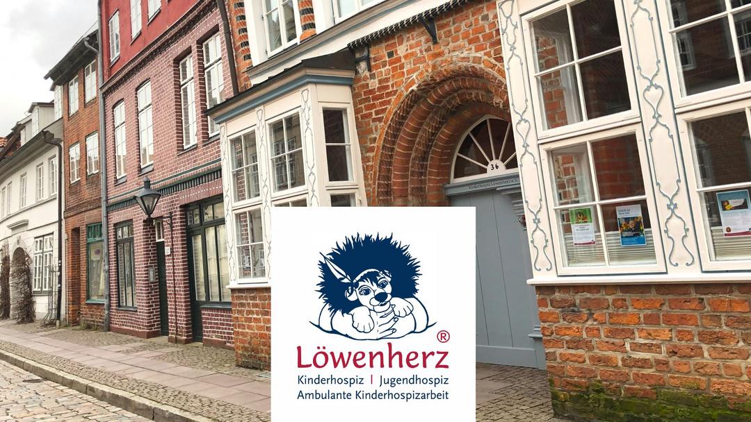 Häuser im Hintergrund, im Vordergrund ein Logo mit Löwe und Schriftzug "Löwenherz"